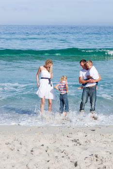 Cheerful family having fun on the sand at the beach