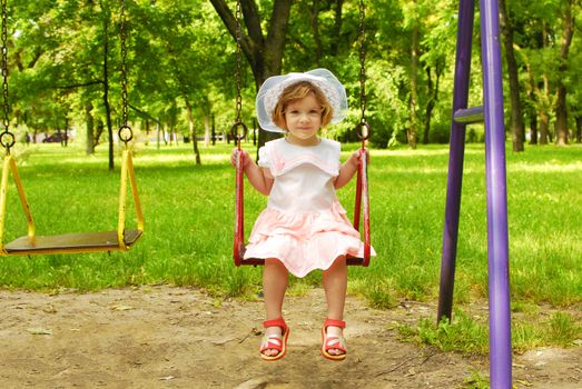 Beauty little girl sitting on the swing