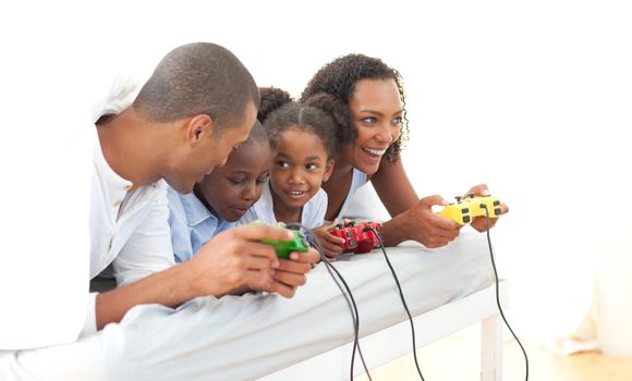 Lively family playing video game lying down on bed at home