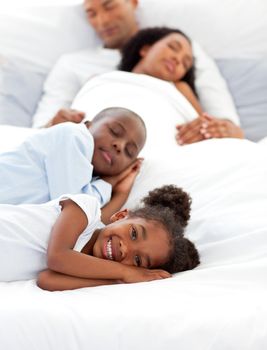 Happy family having fun lying on a bed