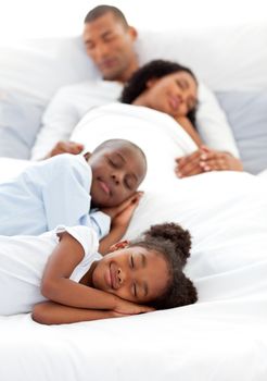 Jolly family sleeping lying on a bed