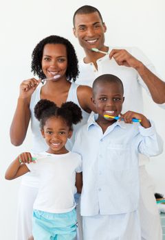 Smiling family brushing their teeth in the bathroom