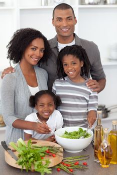 Afro-american family preparing salad together in the kitchen
