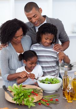 Affectionate family preparing salad together in the kitchen