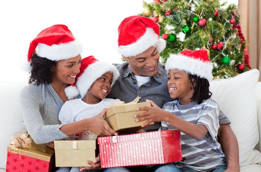 Afro-American family holding Christmas gifts at home