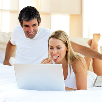Assertive couple drinking coffee lying in the bed at home