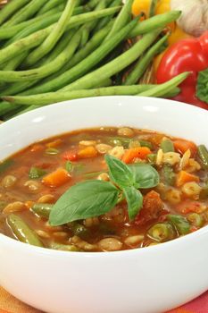 a bowl of minestrone soup and basil