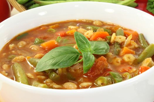 a bowl of minestrone soup and basil