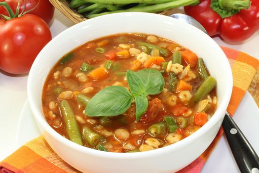 a bowl of minestrone soup and basil