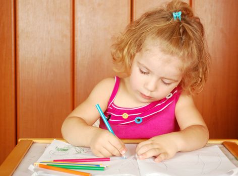 Beauty little girl drawing with crayons