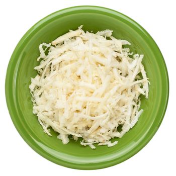 grated celery root (celeriac) on a small green ceramic bowl, isolated on white