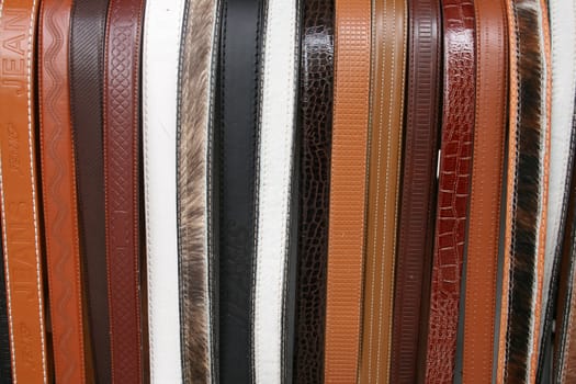 Handmade leather belts in a variety of patterns and colors for sale at the outdoor craft market in Cotacachi, Ecuador