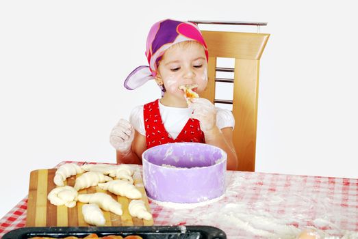 Hungry little girl eat croissant