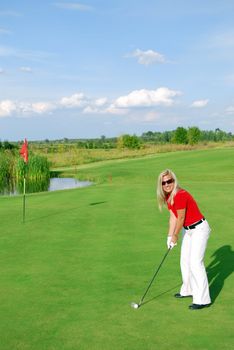 Blonde girl on golf field playing golf