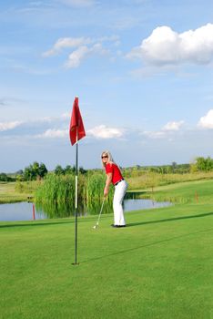 Beauty blonde girl playing golf