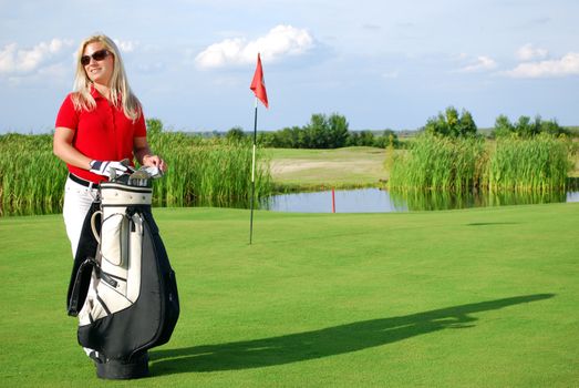 Beauty girl with golf bag on golf course