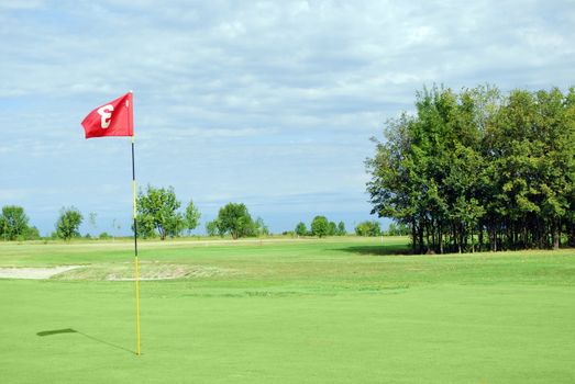 Golf course with red flag number three