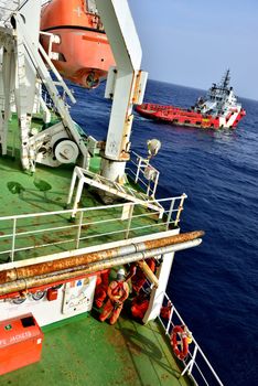 Group of the workers are waiting at oil rig for supply boat.