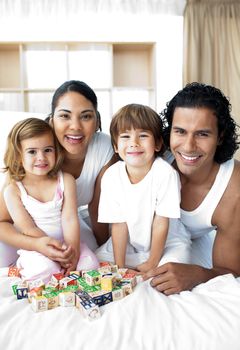 Happy family having fun with cube toys in the bedroom