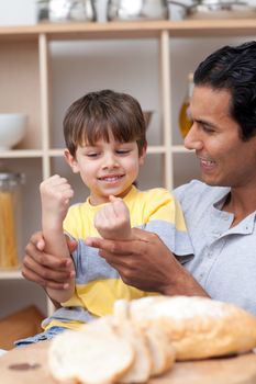 Father and son cutting bread in the kitchen