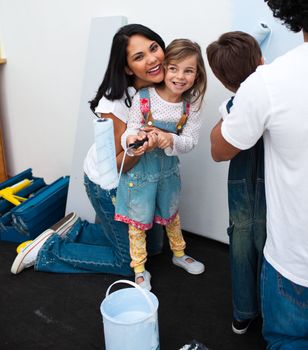 Portrait of little girl painting with her mother at home