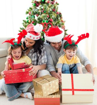 Family decorating a Christmas tree at home