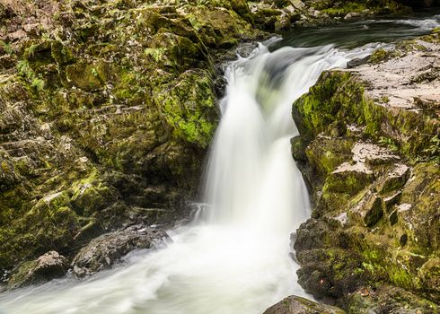 Skelwith Falls waterfall with green moss in slow motion shot in Lake District