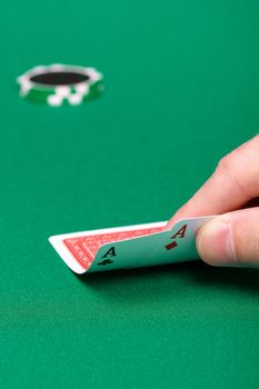 two cards in his hand man on the green table game in a casino