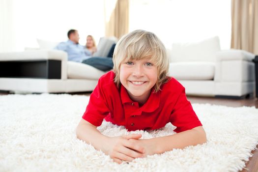 Jolly boy lying on the floor in the living-room