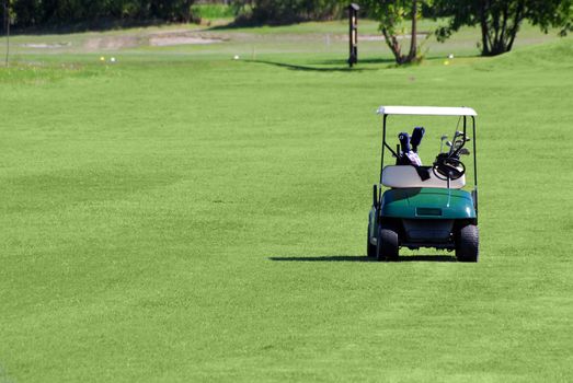 Golf buggy on green grass golf field