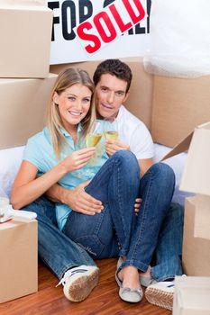 Romantic couple toasting with Champagne after move in