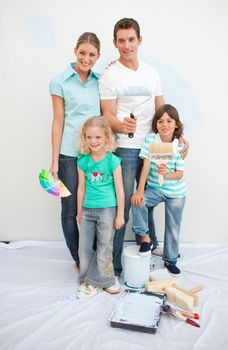 Smiling family decorating their house after move in