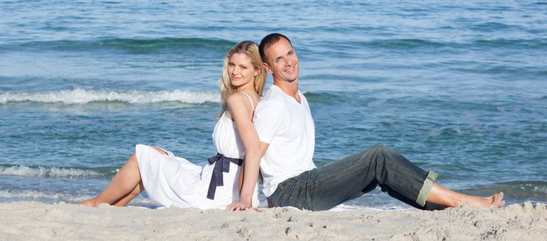 Portrait of couple sitting on sand at the beach