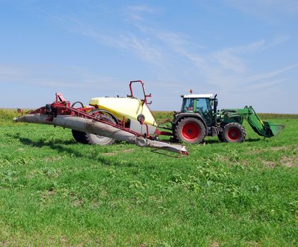 Tractor with sprayer on field