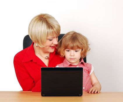 Woman and little girl with laptop studio shot