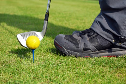 Golfer ready for hit yellow golf ball