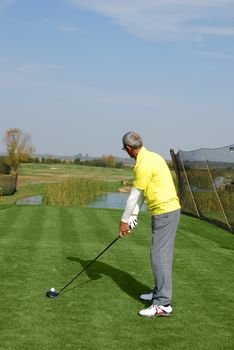 Male golf player ready for hit