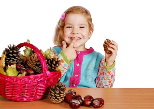 Little girl fun with pine-cone and chestnut