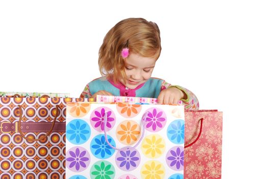 Little girl looking in shopping bags studio shot
