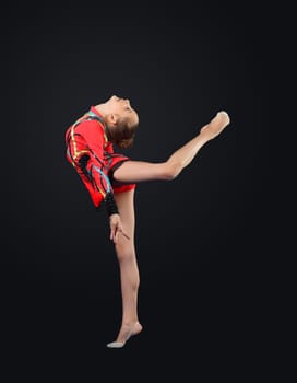 Young cute woman in gymnast suit show athletic skill on black background