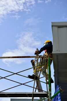 The welder man is welding the steel pipe on the scaffold.