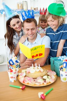 Happy family celebrating father's birthday in the kitchen