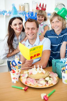 Jolly family celebrating father's birthday in the kitchen