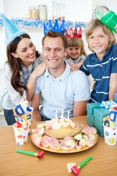 Smiling family celebrating father's birthday in the kitchen