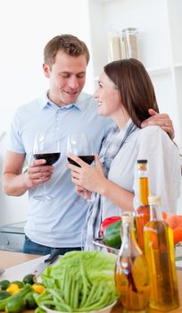 Romantic couple drinking wine while cooking in the kitchen
