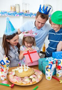 Smiling little girl celebrating her birthday in the kitchen