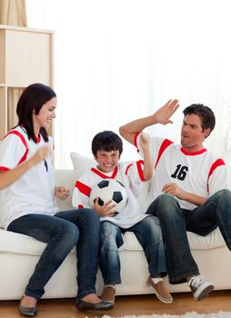 Joyful family watching football match on television