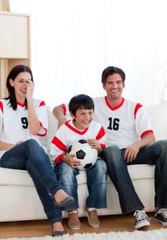 Positive family watching football match on television