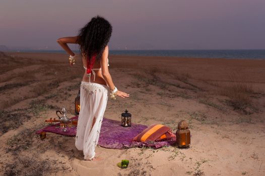 Attractive woman dancing on a dune landscape