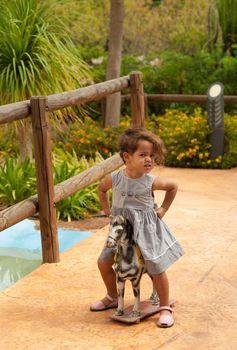 Cute Hispanic girl having lots of fun with a vintage horse toy